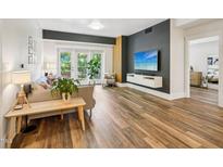 Bright living room with hardwood floors, modern furniture, and sliding doors to the outside at 222 Glenwood Ave # 213, Raleigh, NC 27603