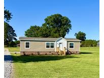 Inviting single-story home with charming front porch, and a lush green lawn at 2232 Tarboro Road Rd, Youngsville, NC 27596