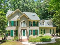 Charming brick two-story home with green shutters, mature trees, and a welcoming entrance at 2401 Worthing Ct, Wake Forest, NC 27587