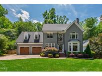 Charming gray two-story home with a manicured lawn, mature trees and an attached two-car garage at 3304 Buck Run Trl, Wake Forest, NC 27587