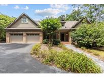 Charming brick home featuring a two-car garage, manicured landscaping, and a welcoming front entrance at 3600 Trail 23 St, Durham, NC 27707