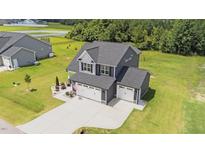 Beautiful home featuring a spacious three car garage and a well-manicured lawn in a suburban setting at 385 Jackson Pond Dr, Smithfield, NC 27577