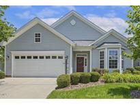 Charming single-story home features a manicured lawn, two-car garage, and a welcoming red front door with a wreath at 400 Indian Elm Ln, Cary, NC 27519