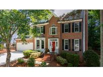 Charming brick two-story home with a red front door and well-manicured landscaping at 405 Widdington Ln, Cary, NC 27519