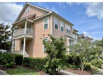 Charming two-story condo with a welcoming porch and well-maintained landscaping under a bright, cloudy sky at 440 Heritage Village Ln, Apex, NC 27502