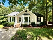 Charming single-story home features a bay window, black shutters, and lush landscaping at 5 Sue Ann Ct, Durham, NC 27704