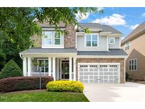 Charming two-story home with stone and siding, a welcoming porch, and a two-car garage at 508 Morning Oaks Dr, Holly Springs, NC 27540