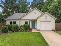 Charming single-story home with well-maintained lawn, mature landscaping, and an attached one car garage at 5801 Hadrian Dr, Durham, NC 27703