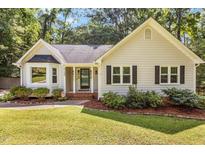 Charming home featuring manicured lawn, mature landscaping, and inviting front porch at 6129 Krandon Dr, Raleigh, NC 27603