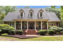 Charming brick home featuring a welcoming front porch with rocking chairs and manicured landscaping at 901 Tamaras Cir, Wake Forest, NC 27587