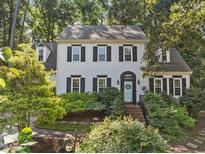 Charming two-story home boasts lush landscaping, a light blue front door, and classic black shutters at 1 Gatesway Ct, Durham, NC 27707