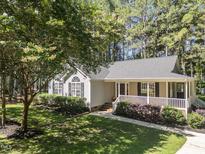 Charming single-story home with a cozy front porch and meticulously landscaped yard at 101 Abram Way, Clayton, NC 27520