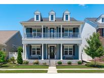 Beautiful two-story home with a covered front porch and well-manicured lawn on a sunny day at 1108 Lowland St, Apex, NC 27523