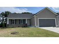 Charming single-story home featuring a covered front porch, attached two-car garage and well-manicured lawn at 116 Oakfield Trace Dr, Four Oaks, NC 27524