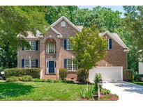 Charming two-story brick home with manicured lawn and blue shutters with attached two car garage at 117 Drakewood Pl, Cary, NC 27518
