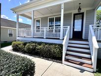 Charming front porch featuring white railing, stairs, and a gray exterior at 118 Chestnut St, Durham, NC 27707