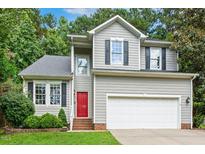 Charming two-story home with gray siding, black shutters, a red door, and an attached two-car garage at 12620 Waterlow Park Ln, Raleigh, NC 27614
