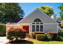 Charming single-story home featuring a red front door, well-manicured landscaping, and a bright, inviting facade at 13 Boxwood Dr, Durham, NC 27713