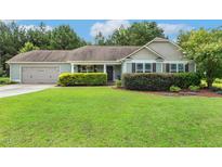 Charming single-story home featuring a well-manicured lawn, attached garage, and lush landscaping at 131 Abacos Ct, Clayton, NC 27520