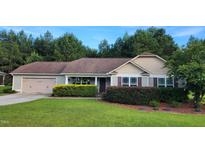 Charming single-story home featuring an attached garage, manicured lawn, and verdant landscaping at 131 Abacos Ct, Clayton, NC 27520