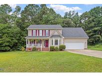 Inviting two-story home with a lush green lawn and attached two car garage at 161 Jacob St, Holly Springs, NC 27540