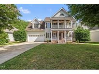 Charming two-story home featuring a welcoming front porch, well-manicured lawn, and attached two car garage at 2027 River Grove Ln, Knightdale, NC 27545