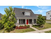 Charming home exterior with a red front door, manicured landscaping, and inviting front porch at 2057 Big Falls Dr, Wendell, NC 27591