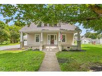 Charming single-story home with a welcoming front porch, green lawn and mature shade trees at 232 S Marshall St, Graham, NC 27253