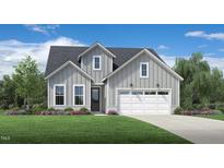 Charming two-story home showcasing a well-manicured lawn and a welcoming two-car garage at 2404 Flemingstone Ln # 51, Raleigh, NC 27610