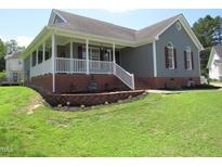 Charming single-story home with a brick foundation, cozy front porch, and a well-manicured front yard at 2662 Walas Ct, Creedmoor, NC 27522