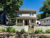 Charming two-story home features a welcoming front porch and a white picket fence at 300 W Roanoke Park Dr, Raleigh, NC 27608