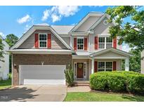 Charming two-story home with brick and siding, red shutters, manicured landscaping, and a two-car garage at 507 Turmeric Ln, Durham, NC 27713