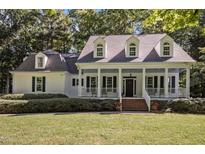 Charming home featuring a spacious front porch,dormer windows,neat landscaping and a well-maintained lawn at 5216 Woods End Rd, Hillsborough, NC 27278