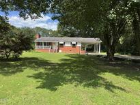Charming single-story brick home with a covered porch, carport, and lush green lawn at 607 S Smithfield Rd, Knightdale, NC 27545