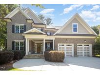 Charming two-story brick home with a welcoming front porch and a two-car garage at 7809 Chestnut Branch Ct, Raleigh, NC 27612