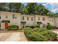 Charming townhouse with well-maintained landscaping, inviting facade, and convenient parking at 8 Mandy Ct, Durham, NC 27707