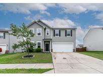 Traditional two-story home with a two-car garage, green lawn, and nicely landscaped yard at 8005 Caithness St, Raleigh, NC 27616