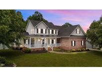 Charming two-story home showcasing a brick and siding facade, a covered porch, and a well-manicured lawn at 81 Northcliff Ct, Clayton, NC 27527