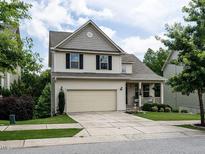 Charming two-story home featuring a welcoming front porch and attached two car garage at 857 Stable Fern Dr, Fuquay Varina, NC 27526