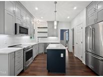 Beautiful kitchen with gray cabinets, stainless appliances, and central island with a white countertop at 8640 Swarthmore Dr, Raleigh, NC 27615