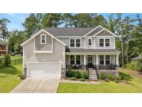 Charming two-story home with a well-manicured lawn, inviting front porch, and attached two-car garage at 103 Foothill Ct, Sanford, NC 27330