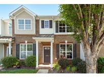 Charming brick townhome with a covered entryway and well-manicured landscaping at 1076 Kelso Ln, Burlington, NC 27215