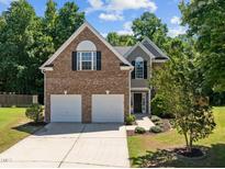 Charming two-story brick home with a two-car garage and landscaped front yard at 110 Bonhill Ct, Apex, NC 27502