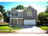 Charming two-story home with a stone accent wall, inviting front porch, and well-maintained lawn at 1122 Birkdale Dr, Mebane, NC 27302