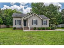 Charming single-story home featuring a well-maintained lawn and classic curb appeal with inviting front entrance and dark shutters at 1203 First Street Ext, Nashville, NC 27856