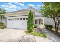 Charming home exterior with a two-car garage, manicured lawn, and inviting covered front porch at 1204 E Rosedale Creek Dr, Durham, NC 27703