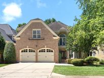 Traditional brick home with a two-car garage and a manicured front lawn, framed by lush trees at 12257 Beestone Ln, Raleigh, NC 27614