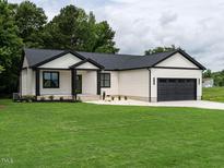 Charming single-story home featuring black trim, white siding, and a well-manicured lawn at 1328 Bethlehem Church Rd, Youngsville, NC 27596