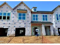 New construction home showcasing large windows, durable wrap, and open garage with a blue sky above at 161 Ripple Way # 206, Clayton, NC 27520