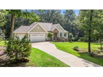 Charming home with a stone arched entryway, attached garage, and well manicured lawn at 186 Ross Dr, Pittsboro, NC 27312